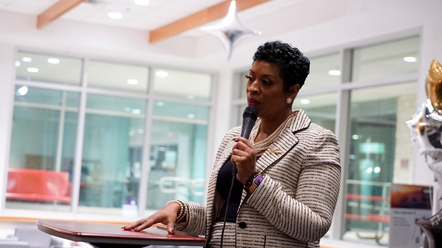 Woman speaking with microphone indoors.